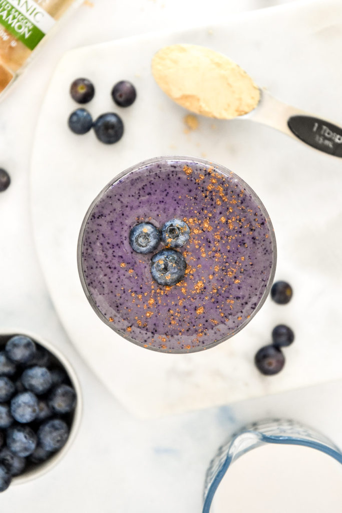 peanut butter powder blueberry cinnamon smoothie in a glass mason jar.