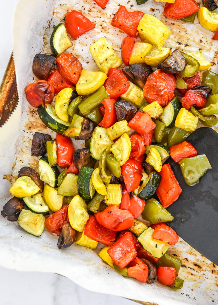 roasted veggies on a sheet pan with parchment paper.