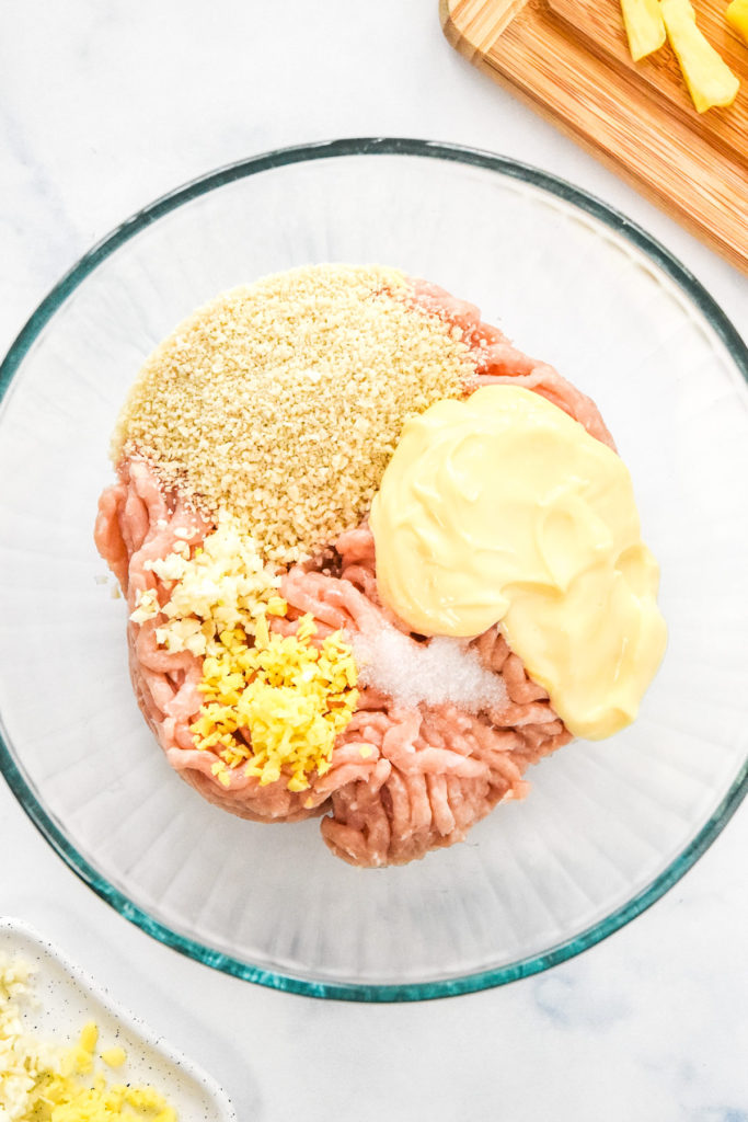 ground chicken, breadcrumbs, mayo and spices in a bowl before mixing up meatballs.