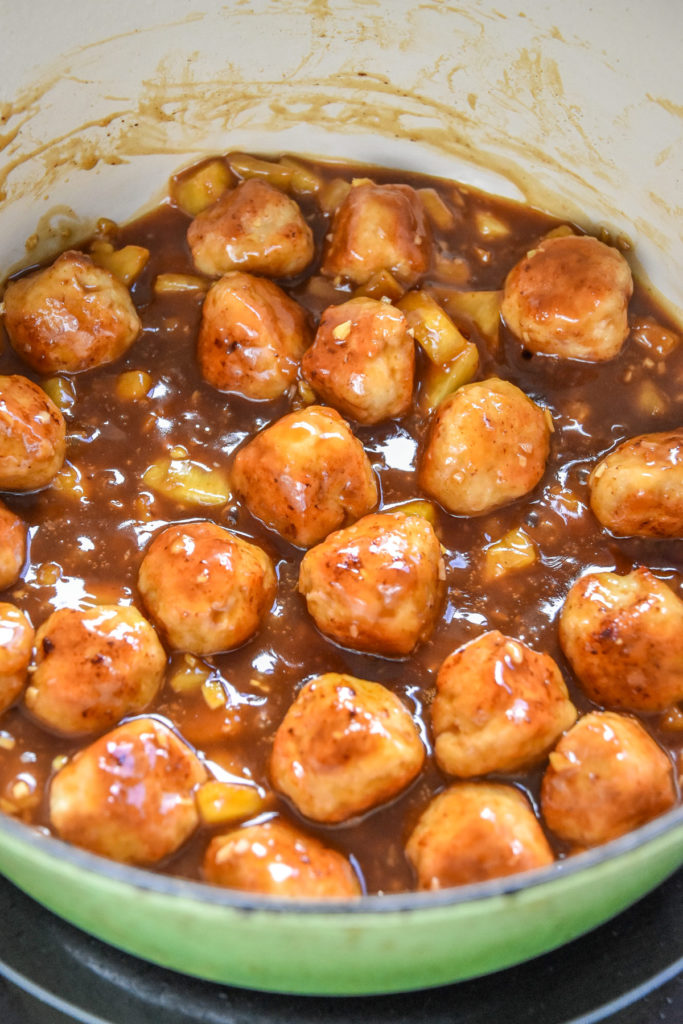 cooked homemade pineapple teriyaki chicken meatballs in a pan.