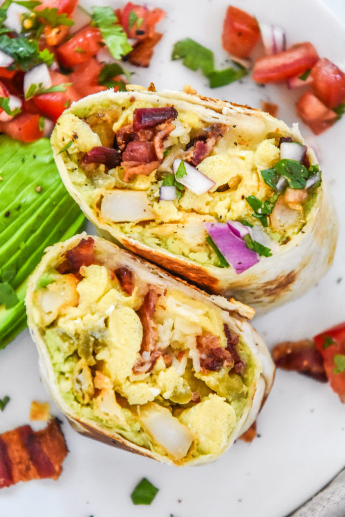 california style breakfast cut in half on a white plate.