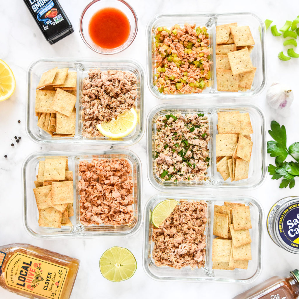 DIY flavored tuna packets  with crackers in glass meal prep containers.