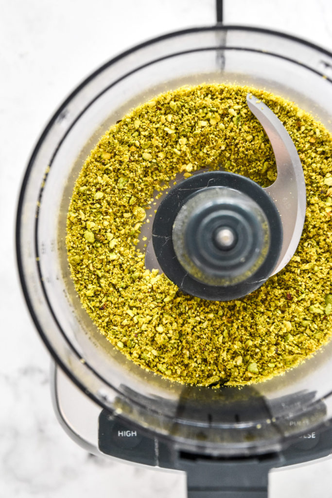 pistachio crumbs in the food processor bowl after blitzing.