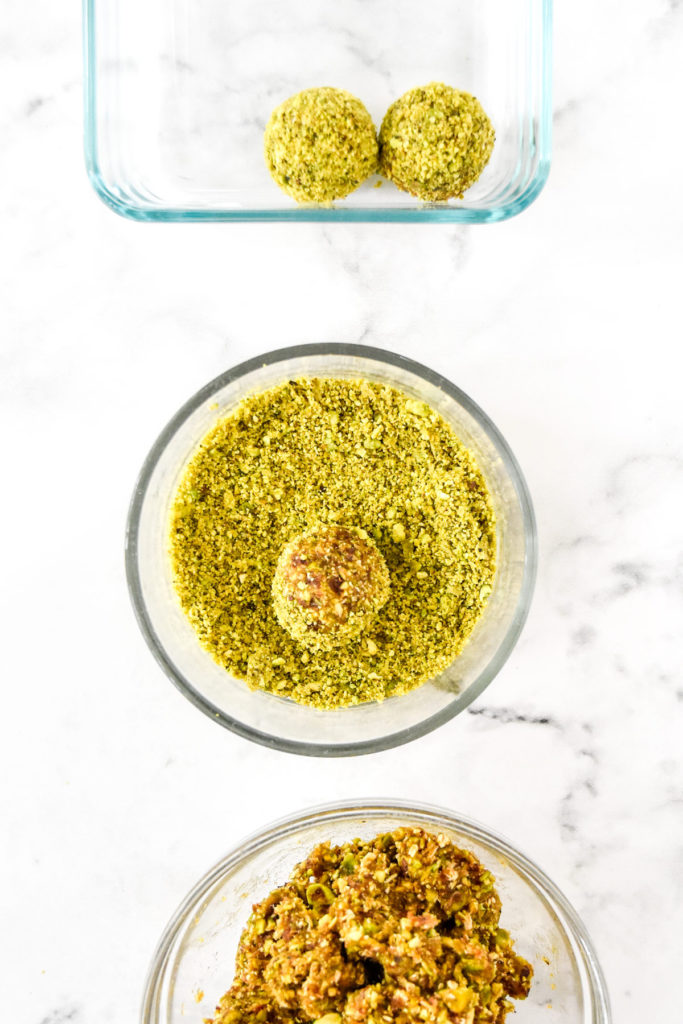 assembly line of bowls to roll the pistachio date energy balls in crumbs and then storage container.