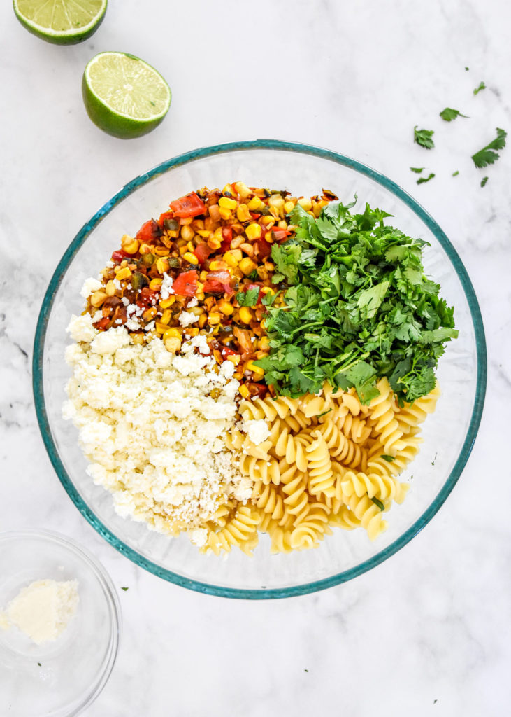 pasta, cotija, cilantro and cooked veggies in a bowl before mixing.