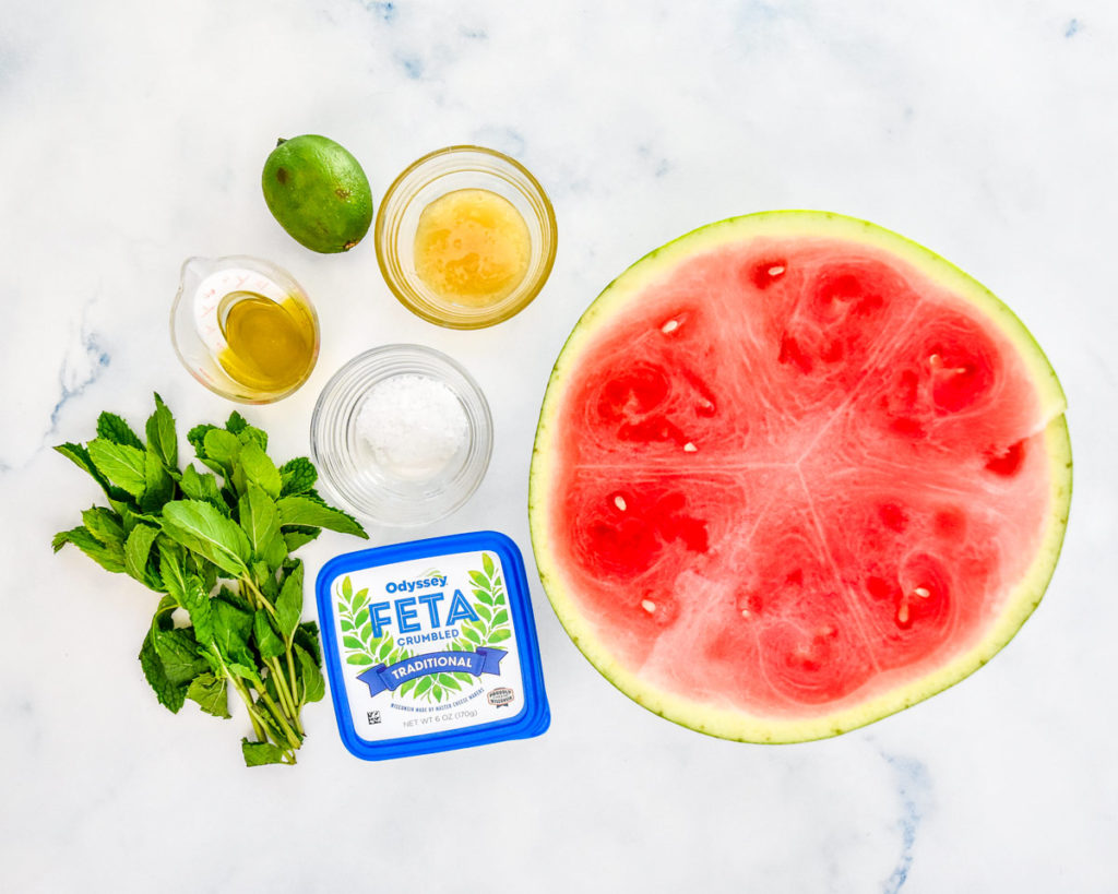 half a watermelon and other ingredients required to make watermelon feta mint salad.