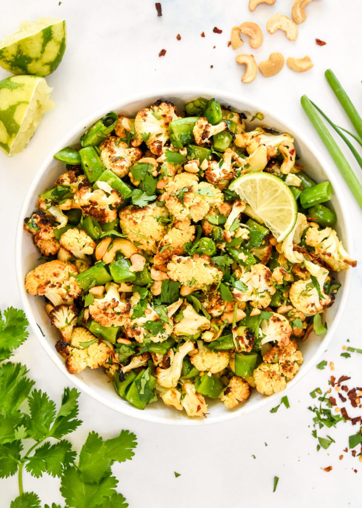 chili lime roasted cauliflower salad in a bowl with cilantro and cashews on top.