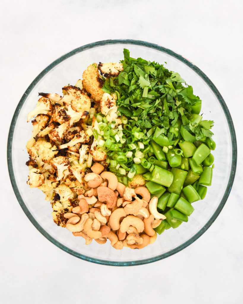 ingredients in the bowl for the chili lime roasted cauliflower salad before mixing.